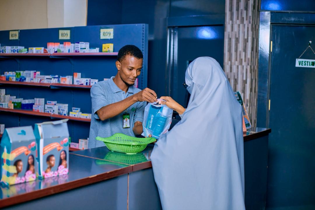 Pharmacien remettant un médicament à une cliente